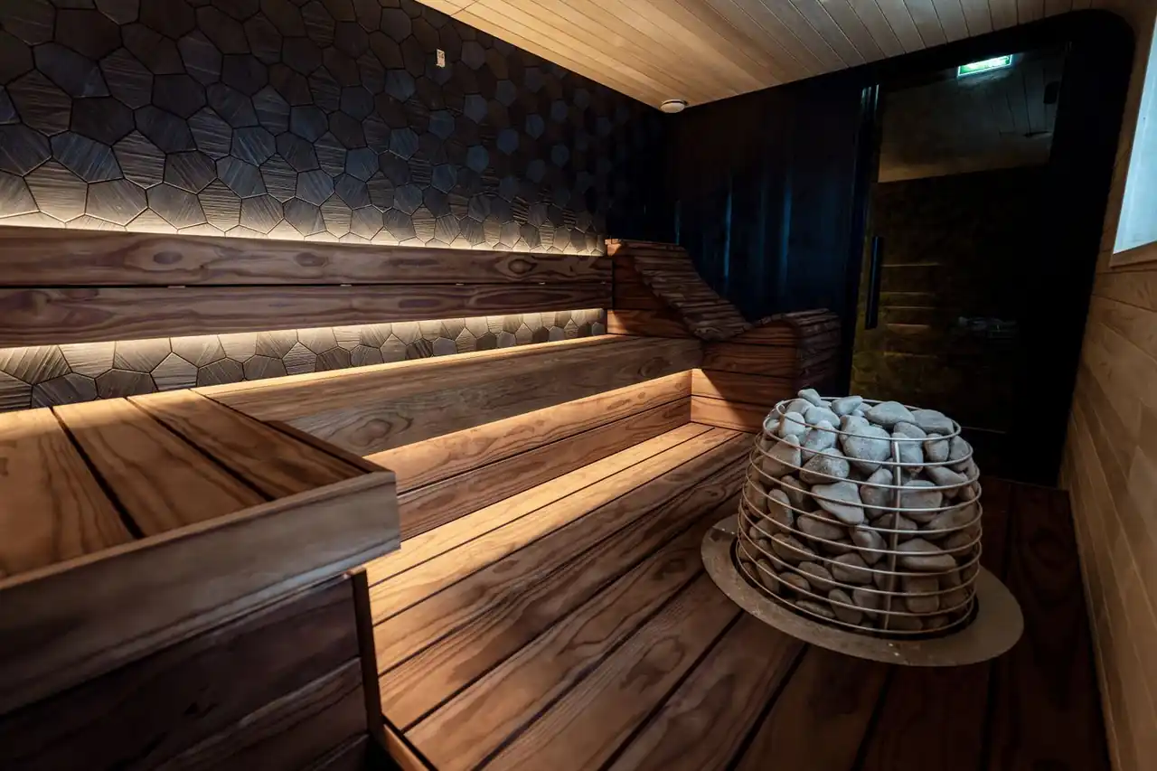 Serene interior sauna with warm ambient lighting and honed timber benches