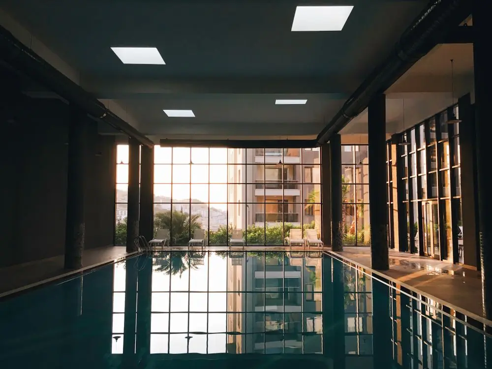 Architectural indoor bathing pool framed by natural light and pale stone